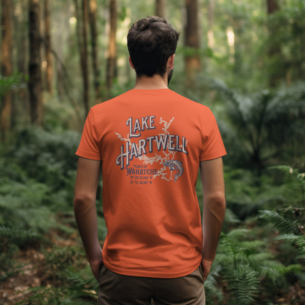 Back view of a man standing in a forest wearing the Reelfly Outdoors Lake Hartwell T-Shirt in the color Orange.